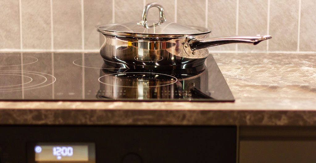 Vue de profil d'une personne posant un couvercle en verre sur une casserole pendant la cuisson dans une cuisine moderne